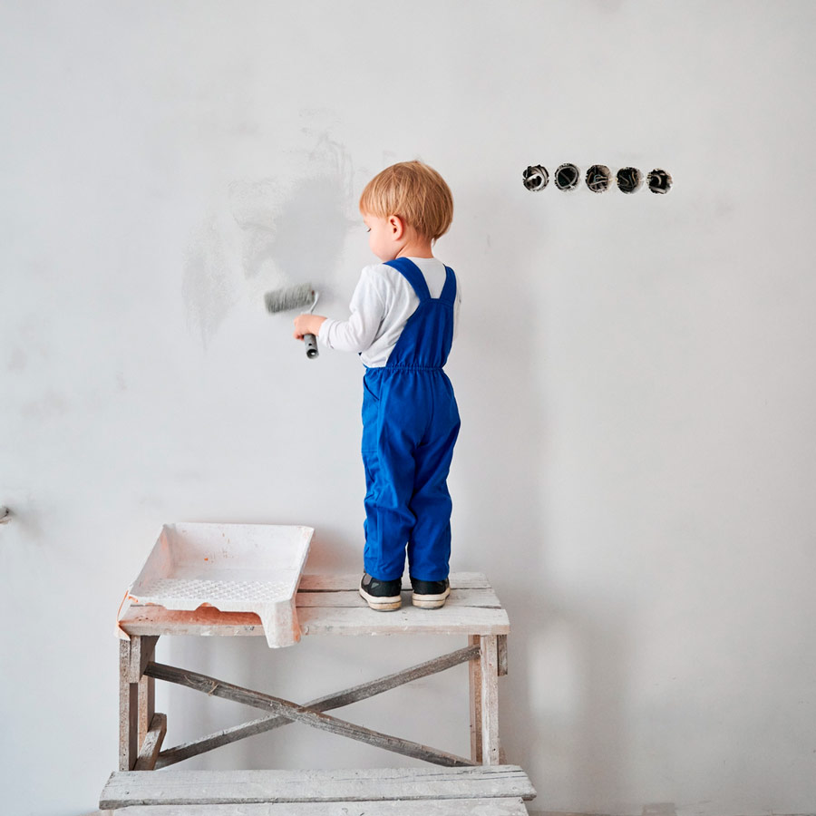 Niño tratando de mostrar cómo pintar una habitación